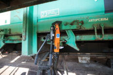 Closing device for load box gate on freight trains